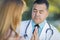 Hispanic Male Doctor Praying With A Patient