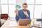 Hispanic man with beard working at the office holding brazilian reals pointing with finger to the camera and to you, confident