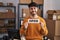 Hispanic man with beard working at small business ecommerce holding open sign smiling with a happy and cool smile on face