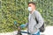 Hispanic man on a bicycle, wearing a medical mask to protect the Covid-19