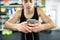 Hispanic man in gym resting, holding smart phone,listening music