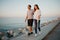 A Hispanic man and his girlfriend are strolling on a breakwater in Spain