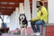 Hispanic man holding the leash of his Alaskan Malamute dog sitting under the bridge