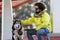 Hispanic man holding the leash of his Alaskan Malamute dog sitting under the bridge