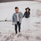 Hispanic man in oversized denim jacket and woman in hat leather biker jacket