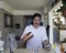 Hispanic man pouring drink at home