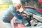 Hispanic man with a protective mask fixing a car engine