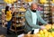 Hispanic man in protective mask looking for bananas in supermarket