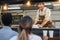 Hispanic man serving take away food inside food truck - Focus on chef face