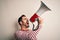 Hispanic man shouting angry on protest through megaphone