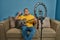 Hispanic man on a sofa in front of his tablet Greeting fellow students in the online guitar class