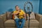 Hispanic man on a sofa in front of his tablet Greeting fellow students in the online guitar class