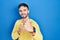 Hispanic man standing over blue background punching fist to fight, aggressive and angry attack, threat and violence