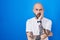 Hispanic man with tattoos standing over blue background thinking looking tired and bored with depression problems with crossed