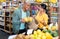 Hispanic married couple choosing bananas in grocery store