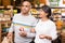 Hispanic married couple visiting grocery store for shopping
