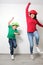 Hispanic mom and son play, jump and have fun together with funny hats spend quality family time very happy