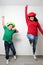 Hispanic mom and son play, jump and have fun together with funny hats spend quality family time very happy