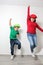 Hispanic mom and son play, jump and have fun together with funny hats spend quality family time very happy