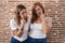 Hispanic mother and daughter wearing casual white t shirt pointing to the eye watching you gesture, suspicious expression