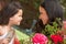 Hispanic Mother And Daughter Working In Garden Tidying Pots