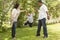 Hispanic Mother and Father Swinging Son in the Park