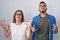 Hispanic mother and son standing together crazy and mad shouting and yelling with aggressive expression and arms raised