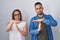 Hispanic mother and son standing together doing time out gesture with hands, frustrated and serious face