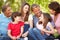 Hispanic mulit generation family sitting in park