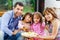 Hispanic parents with two daughters eating from a