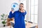 Hispanic service man holding a gallon bottle of water for delivery pointing with finger to the camera and to you, confident