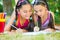 Hispanic sisters drawing in summer park