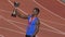 Hispanic sportsman with gold medal on chest holding cup, realizing his victory