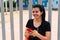 Hispanic sportswoman standing in a park checking her cell phone