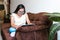 Hispanic teen girl with down syndrome using a tablet while sitting on the sofa at home, in disability concept in Latin America