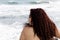 Hispanic Woman Bare Back With Ocean Waves