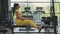 Hispanic woman does exercises on the rowing machine. A girl sits behind a simulator is called a rowing machine. sitting