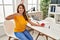 Hispanic woman donating blood pointing finger to one self smiling happy and proud