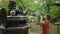 Hispanic woman in glasses captures japan\\\'s ancient gotokuji temple beauty with her phone, enjoying her role as a tourist