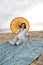 Hispanic woman with parasol on beach blanket