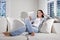 Hispanic woman reading electronic book on couch