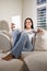 Hispanic woman reading electronic book on couch