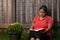 Hispanic Woman Reading Her Bible by Flower Pot