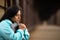 Hispanic Woman Sitting On A Bridge Praying While Holding Bible