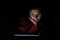 Hispanic Woman Using Electronic Tablet in Dark Environment Lit by Tablet