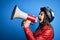 Hispanic woman wearing vintage motorbike helmet shouting angry on protest through megaphone