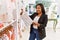 Hispanic woman working as shop assistant at children clothes small retail trade