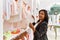 Hispanic woman working as shop assistant at children clothes small retail trade