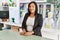 Hispanic woman working as shop assistant at children clothes small retail trade