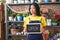 Hispanic woman working at florist holding open sign clueless and confused expression